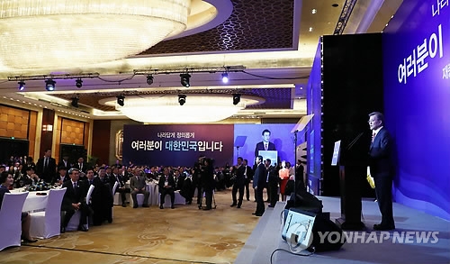 South Korean President Moon Jae-in (R) speaks in a meeting with some 400 South Korean residents in Beijing on Dec. 13, 2017. (Yonhap)