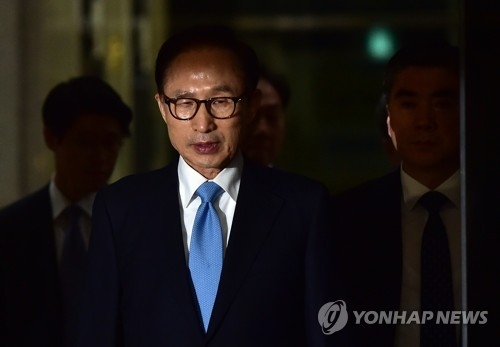 Former President Lee Myung-bak leaves the Seoul Central District Prosecutors' Office on March 15 after undergoing 21 hours of questioning over multiple corruption charges. (Yonhap) 