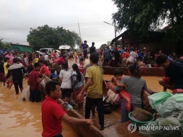 The photo provided by the Lao News Agency KPL shows people evacuating from the affected area near the Xepian-Xe Nam Noy hydropower plant in the San Sai district of Attapeu province in southeast Laos on July 24, 2018. (Yonhap)