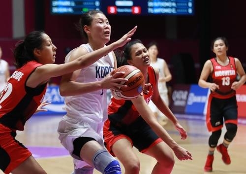 North Korean center Ro Suk-yong (C) of the unified Korean women's basketball team drives to the basket against Indonesia in the teams' preliminary action at the 18th Asian Games at GBK Basketball Hall in Jakarta on Aug. 15, 2018. (Yonhap)