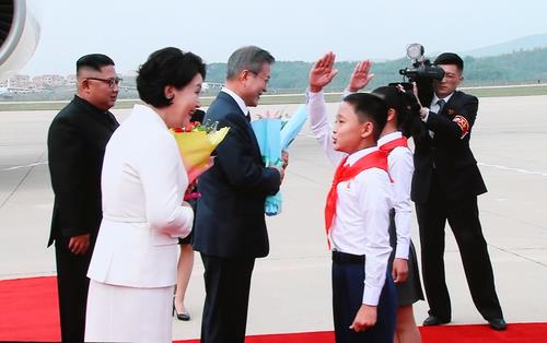 South Korean President Moon Jae-in (3rd from L) and first lady Kim Jung-sook receive flowers from North Korean children during a welcome ceremony at Sunan International Airport in Pyongyang on Sept. 18, 2018. (Yonhap)