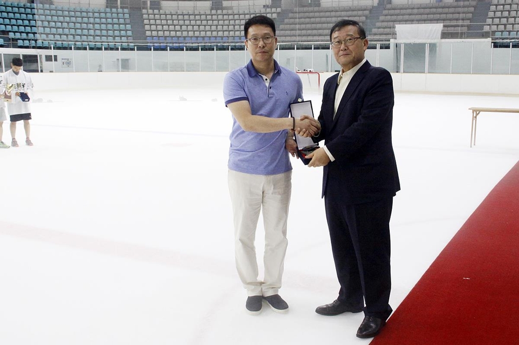 In this undated file photo provided by the Korea Ice Hockey Association (KIHA) on Oct. 16, 2018, Kim Sang-joon, newly named head coach of the women's national team, shakes hands with KIHA President Chung Mong-won. (Yonhap)