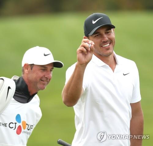 Brooks Koepka of the United States (R) celebrates his chip-in birdie at the 16th hole during the final round of the PGA Tour's CJ Cup @ Nine Bridges at the Club at Nine Bridges in Seogwipo, Jeju Island, on Oct. 21, 2018. (Yonhap)