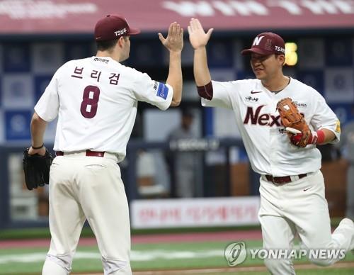 Nexen Heroes' third baseman Kim Min-sung (R) high-fives starter Jake Brigham after completing a triple play against the Hanwha Eagles in the top of the second inning of Game 3 of the Korea Baseball Organization's first-round postseason series at Gocheok Sky Dome in Seoul on Oct. 22, 2018. (Yonhap)