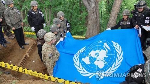 Remains believed to be a U.N. soldier are honored and draped with a United Nations Command (UNC) flag during an informal ritual prayer ceremony at Arrowhead Ridge, Cheorwon, Gangwon Province, on June 11, 2019, in this photo provided by the UNC. (PHOTO NOT FOR SALE) (Yonhap) 