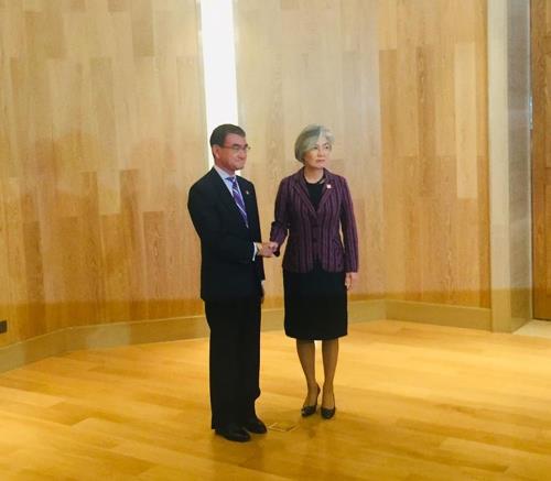 Foreign Minister Kang Kyung-wha shakes hands with her Japanese counterpart, Taro Kono, before their talks in Beijing on Aug. 21, 2019. (Pool photo) (Yonhap)