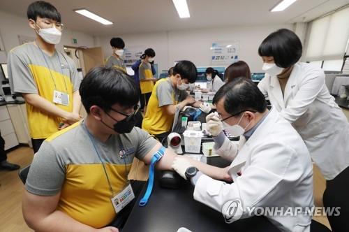 Prospective soldiers wearing masks have their blood taken during a medical checkup at the Seoul office of the Military Manpower Administration on Feb. 3, 2020, part of the year's first batch of applicants evaluated by the office. All able-bodied South Korean males are required to serve roughly two years in the military. (Yonhap)