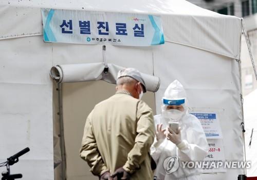 An elderly man listens to a medical professional after arriving at a coronavirus screening clinic in Incheon, west of Seoul, on May 14, 2020, to undergo a COVID-19 test. (Yonhap)