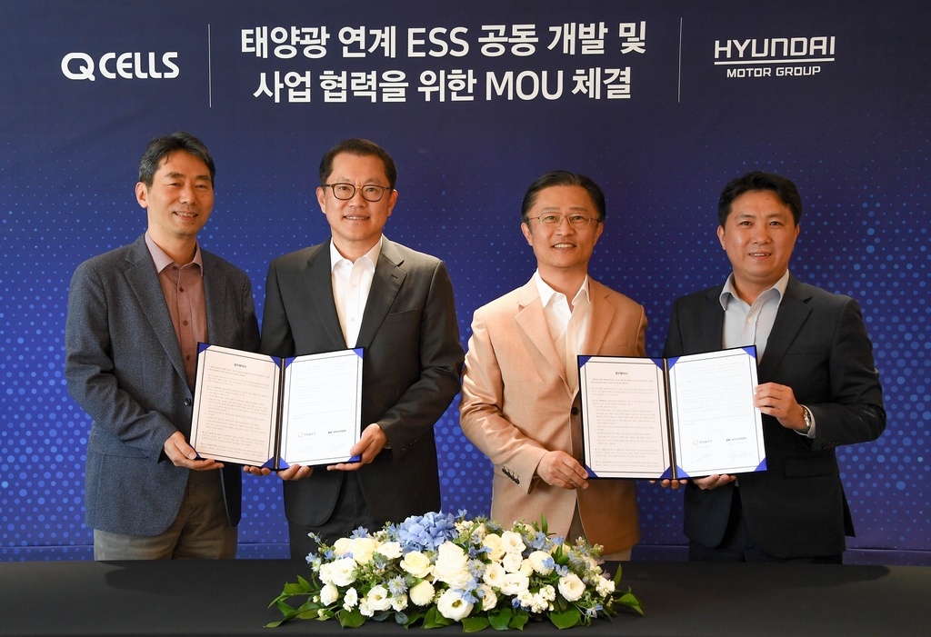 This photo provided by Hyundai Motor Group on May 31, 2020, shows officials from Hyundai Motor Group and Hanwha Q Cells posing after signing a partnership for ESS development. (PHOTO NOT FOR SALE) (Yonhap)