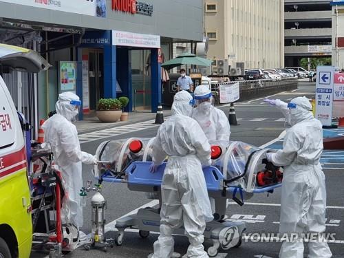 This photo taken by a Yonhap News TV reporter shows medical workers moving a confirmed patient of the new coronavirus to the Kyungpook National University Hospital in Daegu, 302 kilometers southeast of Seoul, on Aug. 30, 2020, as the city reported 30 new daily COVID-19 cases, the highest in more than five months. (PHOTO NOT FOR SALE) (Yonhap)