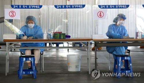 Medical staff members get ready to carry out new coronavirus tests at a makeshift clinic in the southern city of Gwangju on Sept. 28, 2020. (Yonhap)