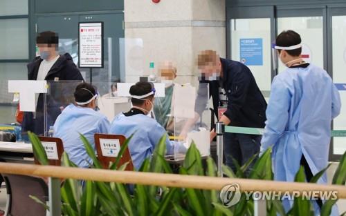 Inbound passengers show their passports to quarantine officials after arriving at Incheon airport, west of Seoul, on Oct. 22, 2020. (Yonhap)
