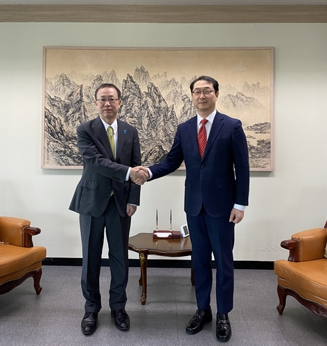 Le représentant spécial pour la paix et la sécurité sur la péninsule coréenne Kim Gunn et Takehiro Funakoshi, le directeur général du ministère japonais des Affaires étrangères pour les affaires de l'Asie et de l'Océanie, échangent une poignée de main lors de leur rencontre à Séoul, le lundi 19 décembre 2022. (Photo fournie par le ministère des Affaires étrangères. Revente et archivage interdits)