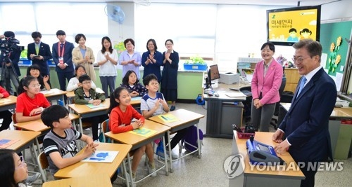 生徒たちに粒子状物質について教える教室を訪れた文大統領＝１５日、ソウル（聯合ニュース）