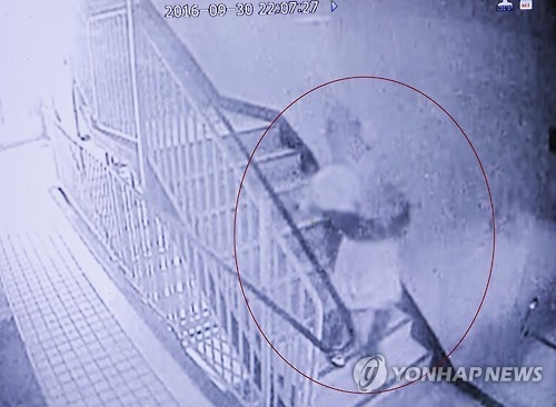 (포천=연합뉴스) 최재훈 기자 = 6살 딸을 살해한 뒤 시신을 불태워 야산에 묻은 뒤 거짓 실종신고를 한 혐의로 양부모가 경찰에 붙잡혔다. 사진은 용의자 중 한 명으로 추정되는 인물이 사건 당일인 지난달 30일 오후 10시께 죽은 6살 어린이로 추정되는 시신을 품아 안고 아파트 계단으로 내려가는 모습.2016.10.2.jhch793@yna.co.kr (끝)