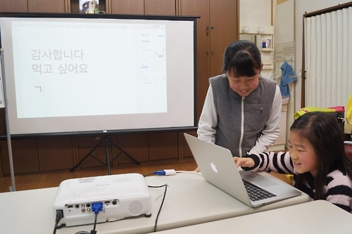 우토로 마을 어린이들이 새로 들어온 교육 물품을 사용하고 있다