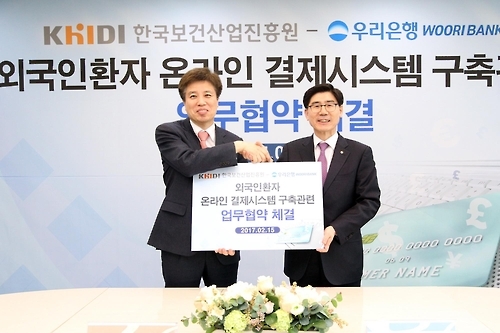 이영찬 한국보건산업진흥원장(왼쪽)과 이광구 우리은행장이 지난 15일 서울 중구에 있는 우리은행 본점에서 '외국인환자 유치를 위한 시스템 구축사업 관련 포괄적 업무 협약식' 후 기념촬영을 하고 있다.