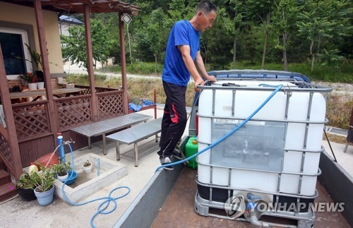 이웃집에서 물을 담는 주민
