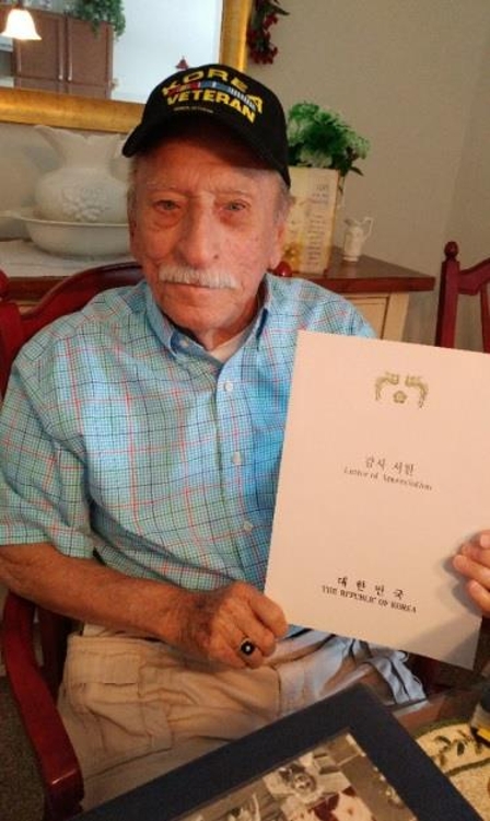 대한민국 정부의 감사서한을 들어보이는 토머스 퀸