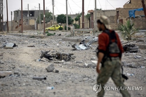 교전에 파괴된 락까 거리의 시리아민주군(SDF) 대원 [AFP=연합뉴스자료사진]