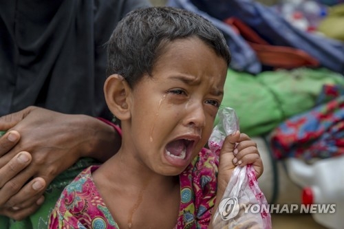 고열을 앓고 있는 로힝야족 소녀가 방글라데시 난민 캠프에 들어가기 위해 가족과 함께 등록을 기다리는 동안 울고 있다. [AP=연합뉴스] 