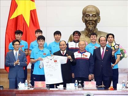 박항서 베트남 U-23(23세 이하) 축구대표팀 감독(오른쪽 2번째)과 선수들이 1월 28일 응우옌 쑤언 푹 베트남 총리(가운데)에게 사인볼과 유니폼을 선물하고 기념사진을 찍는 모습[베트남정부 홈페이지 캡처]