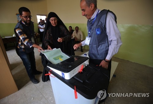 전자 투표시스템에 투표용지를 넣는 이라크 유권자[AFP=연합뉴스자료사진]
