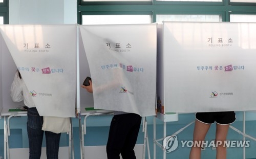 기표소에서 투표하는 시민들