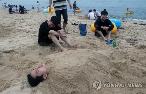 모래찜질하는 해수욕장 피서객