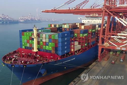중국 산둥성 칭다오항에서 화물선에 컨테이너가 선적되는 모습