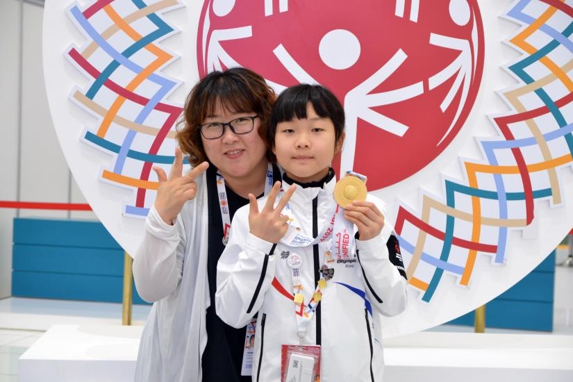 (아부다비=연합뉴스) 김경윤 기자 = 지적장애 롤러스케이팅 대표팀 박하은(오른쪽)이 15일(현지시간) 아랍에미리트 아부다비 국립전시관(ADNEC)에서 열린 제15회 아부다비 스페셜올림픽 롤러스케이팅 여자 100m에서 우승한 뒤 금메달을 받고 어머니인 박진희씨와 포즈를 취하고 있다.cycle@yna.co.kr