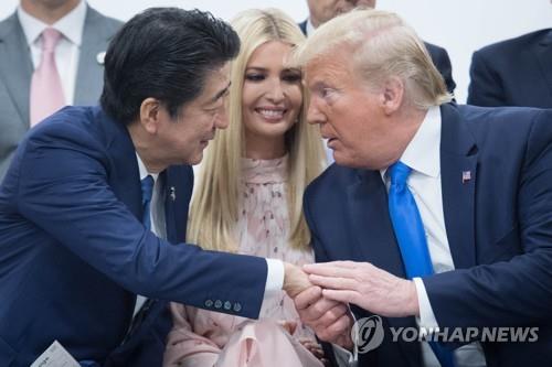 트럼프 대통령과 아베 총리가 지난 6월 29일 오사카에서 열린 G20 정상회의 특별 세션에서 서로 손을 잡은 채 대화하고 있다. [EPA=연합뉴스 자료사진]