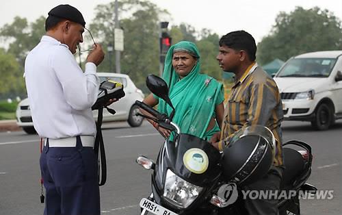 헬멧 미착용 운전자를 단속하는 인도 뉴델리 경찰. [EPA=연합뉴스]