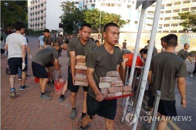 홍콩 시위대가 도로에 설치한 장애물을 치우는 홍콩 주둔 인민해방군