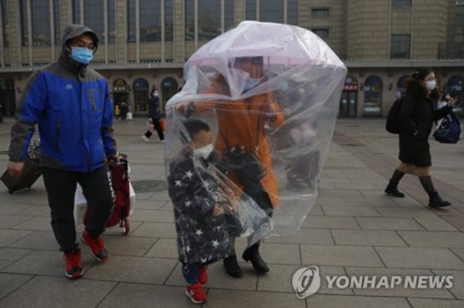 지난 11일 베이징 철도역서 비닐과 마스크로 무장한 가족