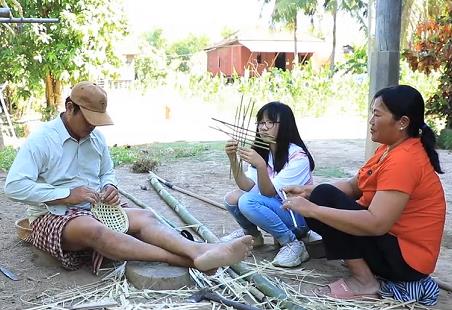 황시아 양(가운데)이 캄보디아 캄퐁참의 외가를 방문해 외할아버지·외할머니와 함께 대나무 그릇을 만들고 있다. [다문화TV 제공] 