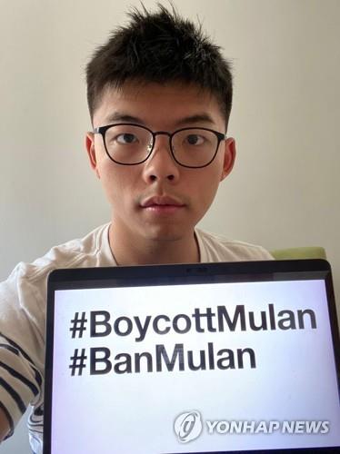 홍콩 민주화 운동가 조슈아 웡이 지난 5일 디즈니 영화 '뮬란'을 보이콧하자는 해시태그를 적은 노트북 화면을 들어보이고 있다.[로이터=연합뉴스]