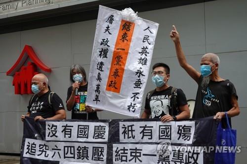홍콩에서 10월1일 국경절 정부 기념식이 열린 행사장 앞에서 민주화 운동가 4명이 시위를 펼치고 있다. [로이터=연합뉴스]