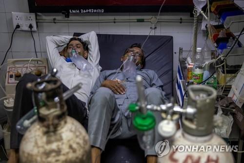 병상 부족에 시달리는 인도 뉴델리 LNJP 병원에서 한 침대를 공유한 채 치료받는 두 명의 코로나19 환자. [로이터=연합뉴스] 