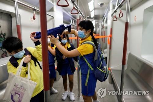 15일 홍콩 '국가안보 교육의 날'에 홍콩 경찰대를 견학온 아이들이 지하철 모형 안에서 장난감 총을 들고 노는 모습. [로이터=연합뉴스]
