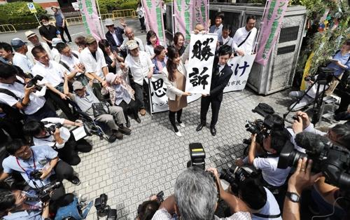 한센병 전 환자의 가족들이 2019년 6월 28일 구마모토지방법원 앞에서 '승소'라고 적힌 펼침막을 들어 보이며 기뻐하고 있다. [교도=연합뉴스 자료사진]