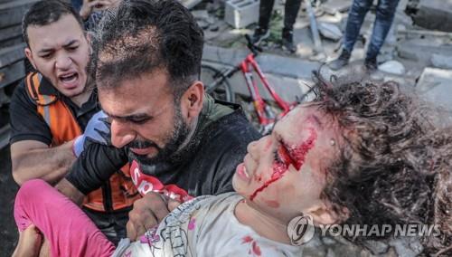 이스라엘의 폭격으로 무너진 건물 더미에서 구해낸 딸을 안은 가자지구 주민