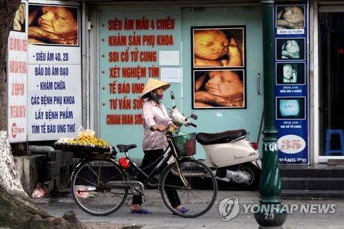 태아의 4차원 이미지를 보여주는 병원 앞을 지나가는 베트남 시민. 2017.9.28