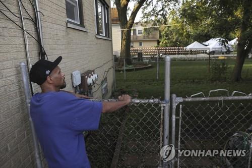 경찰이 시신 발굴 작업을 벌일 예정인 주택 뒷마당을 이웃 주민이 살펴보고 있다. [AP=연합뉴스] 