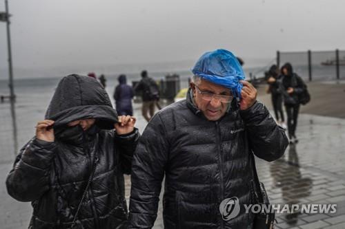 강풍과 비를 피해 달리는 이스탄불 시민