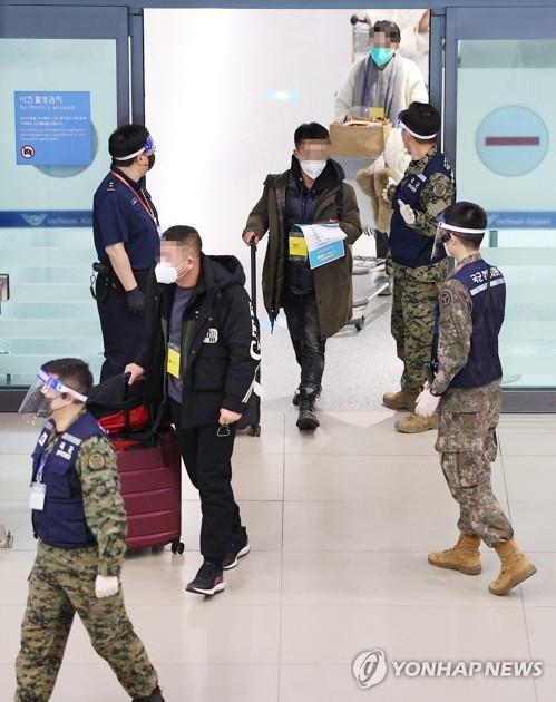 노란색 비표 착용한 채 이동하는 중국발 입국자들
