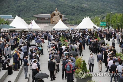 Los ciudadanos esperan en línea, el 14 de julio de 2020, para rendir tributo en el altar fúnebre del héroe de la Guerra de Corea más conocido de Corea del Sur, Paik Sun-yup, en la plaza de Gwanghwamun, en el centro de Seúl, un día antes de su funeral. Paik, el primer general de cuatro estrellas de Corea del Sur, falleció el 10 de julio de 2020, a los 99 años de edad.