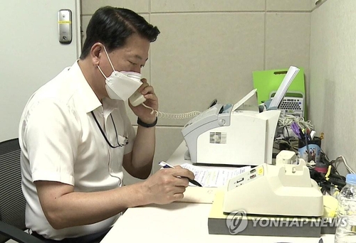 La foto, proporcionada por el Ministerio de Unificación, muestra a un funcionario surcoreano de enlace hablando con su homólogo de Corea del Norte, en el departamento de Seúl de la oficina de enlace conjunta, el 27 de julio de 2021. (Prohibida su reventa y archivo)