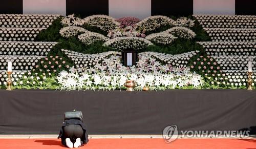 Una persona rinde tributo de rodillas, el 31 de octubre de 2022, en un altar fúnebre instalado en la plaza de Seúl, frente al Ayuntamiento, en el centro de la capital surcoreana, para honrar a las víctimas mortales de la trágica estampida ocurrida, el 29 de octubre, en el barrio de Itaewon.