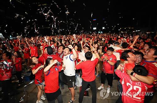 La foto de archivo, tomada el 28 de junio de 2018, muestra a hinchas de fútbol surcoreanos reunidos en la plaza de Seúl, frente al Ayuntamiento de la capital surcoreana, celebrando la victoria de la selección masculina contra Alemania, por 2-0, en la Copa Mundial de la FIFA de Rusia.